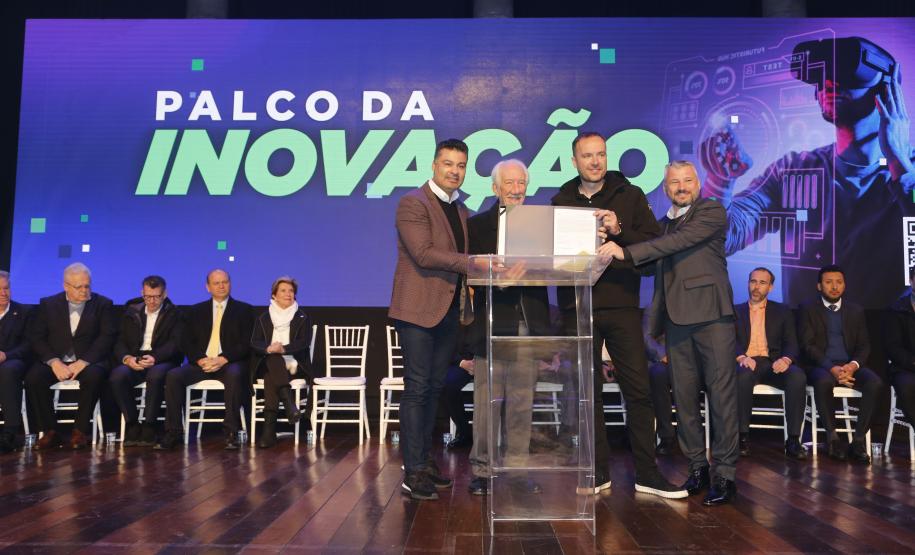 A Fomento Paraná, instituição financeira do Governo do Estado, firmou nesta segunda-feira (19) o primeiro contrato de financiamento Inova Juro Zero durante a abertura da Connect Week. O empresário Marcio Léo Danielewicz, da SYX Global, assinou o contrato junto com o vice-governador Darci Piana, e o secretário estadual de Inovação, Marcelo Rangel. O diretor de Operações do Setor Privado da Fomento Paraná, Renato Maçaneiro, representou a instituição.
